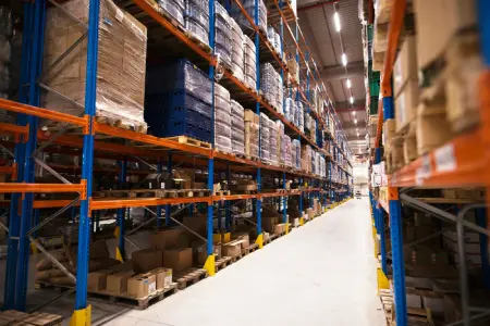 Interior de almacén de distribución con estanterías y palés de mercancía
